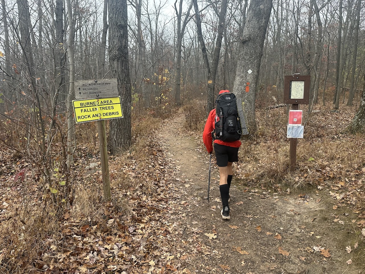 hiker passing trail signs